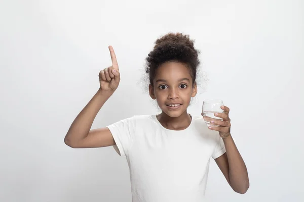 Młoda Dziewczyna Trzyma Szklankę Zwykłej Wody Pitnej Sprawia Wskazując Palcem — Zdjęcie stockowe