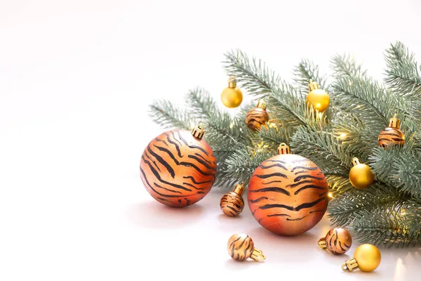 Noel ağacında çelenk ile kaplan çizgisi şeklinde boyanmış Noel topları. Beyaz stüdyo geçmişi. Kış tatili, kaplan yılı, reklamcılık, mutlu yıllar, DIY konsepti. Uzayı kopyala Yatay