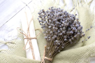 Büyük, kuru bir demet lavanta. Arka planda desenli yeşil el yapımı çuval bezi. Aromaterapi, provence, lavanta üretimi, hasat, ev dekorasyonu, spa, çiçek pazarı.