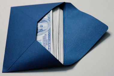 Zarfta para var. Üzerinde Amerikan doları banknotları olan açık bir zarf. On bin dolar. Zenginlik ve gelir kavramı, yolsuzluk, rüşvet, tasarruf. Nakit. Kimse.. 