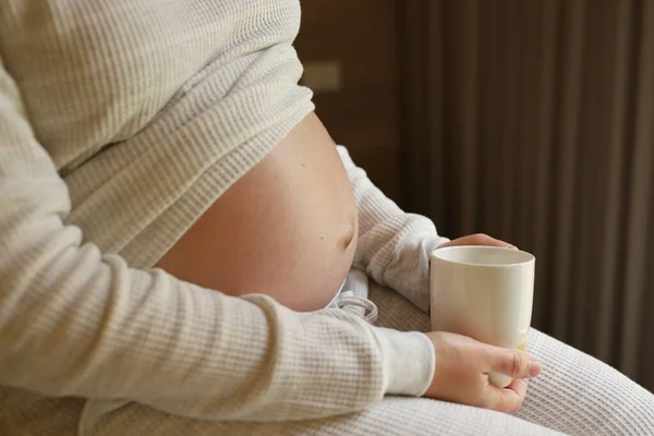 Pregnant Woman Holds Cup Water Her Tummy While Sitting Bed — Stok fotoğraf