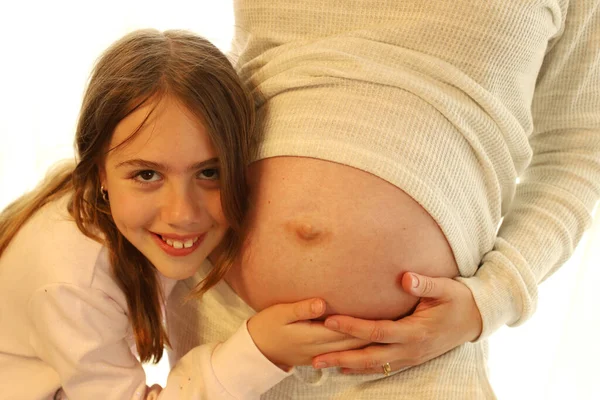 有一个大孩子的快乐女人 一个女孩抱着一个怀孕的妈妈 家庭的概念 母女关系 为人父母 生活方式 — 图库照片