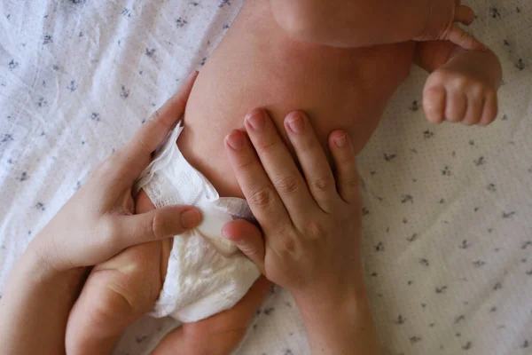 妈妈的手按摩一个患感冒的新生儿的腹部 妈妈轻轻地按摩她1 2个月大的孩子的腹部 图库图片