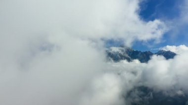 Bulutların üzerinde. Bulutlar ve dağ zirveleriyle muhteşem bir arka plan. Bulutlardaki yüksek dağlar