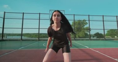 Bir bayan basketbolcuyu yakından çek, beyaz bir kız salya akıtıyor, top sürüyor, sağa sola adımlar atıyor.