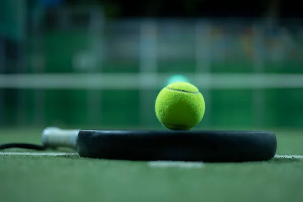 人工芝の上にテニスラケットとボールをパドル ロイヤリティフリーのストック写真