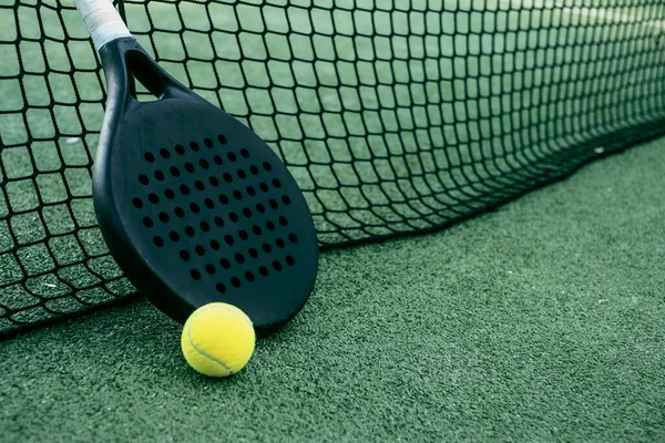 Tenis raketleri ve topları suni çimlerin üzerine koyun.