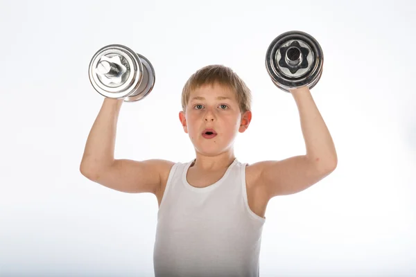 Junge trainiert mit zwei Kurzhanteln — Stockfoto