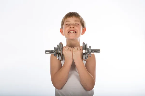 Νεαρό αγόρι άσκηση με έναν αλτήρα — Φωτογραφία Αρχείου