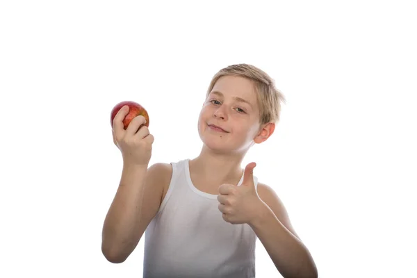 若い少年の赤いりんごと親指のアップ ストック写真