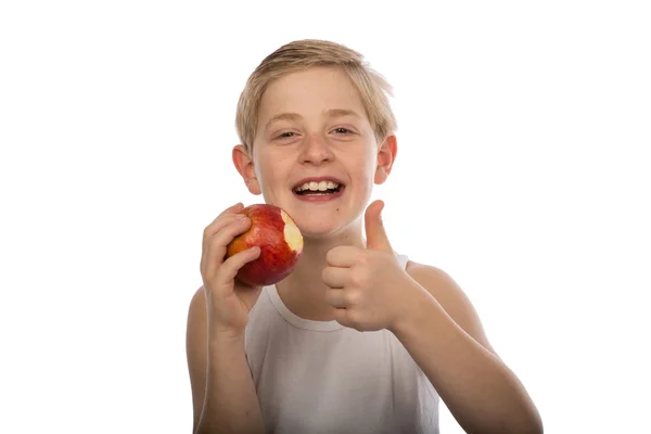 赤いリンゴを食べる若い男の子 ストック画像