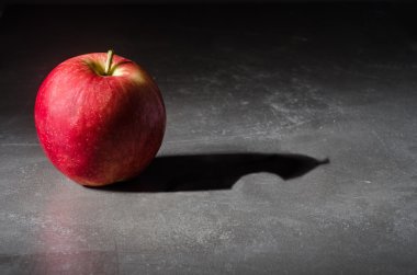Apple with a bite in the shadow clipart