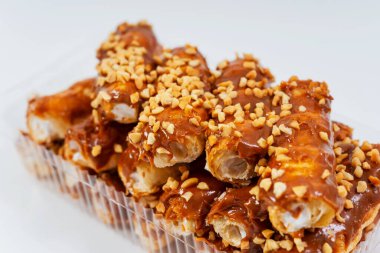 Beyaz arka planda ev yapımı eklerlerdi. Krema ambalajlı, şeffaf plastik kaplar yakın çekim görüntüsü olan eklem tüpleri. Satılık ev yapımı kekler