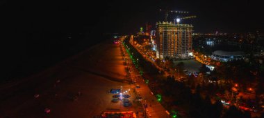 Gürcistan 'ın Batumi kentinde Karadeniz kıyısında bir bina inşa ediliyor. Batumi 'de gece görüş sahasında toprak ve sahil.