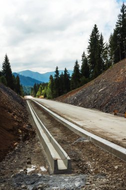 Dağlık bir bölgede yeni bir yol inşaatı. Dağlar arasında beton otoyol. Gürcistan 'da yeni yol