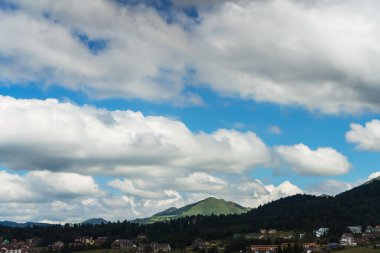 Gürcistan 'daki Bakuriani kayak merkezinin panoramik manzarası. Bulutların ve dağ ormanlarının arka planında bir köy.