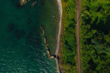 Kobuleti 'deki vahşi sahile yakın demiryolu. Gürcistan 'ın Karadeniz kıyısındaki Batumi kıyı şeridi boyunca uzanan demiryolu insansız hava aracı manzaralı. Georgia 'da Adjara Sahili