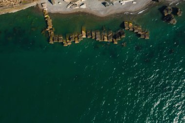Kobuleti 'deki vahşi sahilde dalgalar. Gürcistan 'daki Karadeniz üzerinde Batumi' de taştan dalgalı sulara sahip kıyı ve deniz insansız hava aracı görüşü. Rocky plajı ve deniz manzarası yukarıdan.