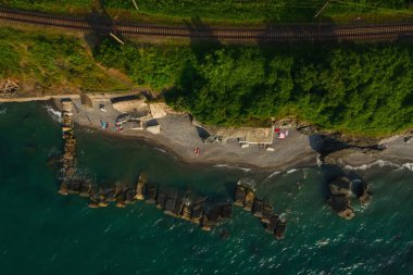 Kobuleti 'deki vahşi sahilde dalgalar. Gürcistan 'daki Karadeniz üzerinde Batumi' de taştan dalgalı sulara sahip kıyı ve deniz insansız hava aracı görüşü. Rocky plajı ve deniz manzarası yukarıdan.