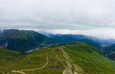 Gürcistan 'da Svaneti' nin Mestia kasabası yakınlarındaki Koruldi Gölü yakınlarındaki dağlar. Gökyüzü manzaralı dağların manzarası. Yağmurlu havada yeşil dağlar