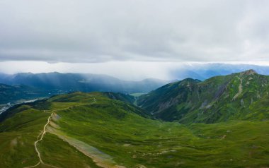 Gürcistan 'da Svaneti' nin Mestia kasabası yakınlarındaki Koruldi Gölü yakınlarındaki dağlar. Gökyüzü manzaralı dağların manzarası. Yağmurlu havada yeşil dağlar