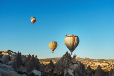 Kapadokya 'da bir vadide balonlar. Türkiye' de Kapadokya 'da gökyüzünde balonlar. Gökyüzünde renkli renkli balonlar uçuşuyor.