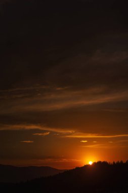 Türkiye 'deki dağlarda gün batımında güzel, ateşli bir gökyüzü. Batan güneşe karşı bulutların dokusu