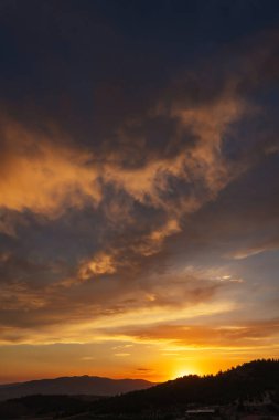 Türkiye 'deki dağlarda gün batımında güzel, ateşli bir gökyüzü. Batan güneşe karşı bulutların dokusu