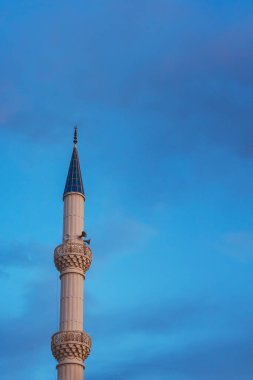 Şafakta gökyüzüne karşı cami minaresi. Hoparlörlü cami kulesi.
