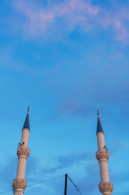 Şafakta gökyüzüne karşı cami minaresi. Hoparlörlü cami kulesi.