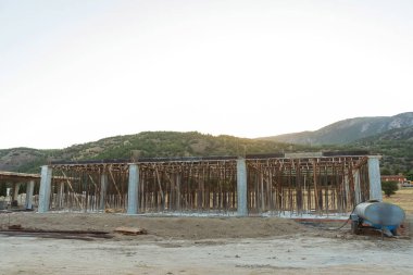 Dağların arka planına karşı Türkiye 'de bir ev inşaatı. Güçlendirilmiş beton bir binanın ereksiyonu. Formwork Prop Desteklemek için Ayarlanabilir Çelik Tüpü Desteği