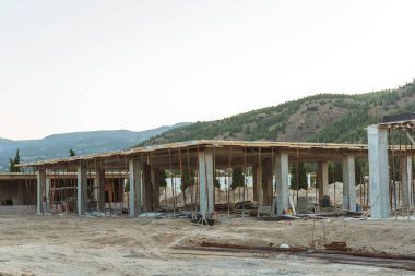 Dağların arka planına karşı Türkiye 'de bir ev inşaatı. Güçlendirilmiş beton bir binanın ereksiyonu. Formwork Prop Desteklemek için Ayarlanabilir Çelik Tüpü Desteği