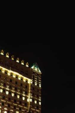 Batumi şehrinde güzel aydınlatılmış bir otel. Siyah arka planda fenerleri olan binalar