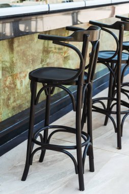 black bar stool outside. tall black chair next to the bar