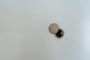 Peephole on a white door. safety hole with a lens for monitoring guests