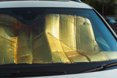 Protective foil from the sun on the windshield. Car protective film to protect the panel. old reflective foil