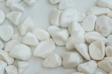 white river pebbles on a white background. small white stones on a white sheet of paper.