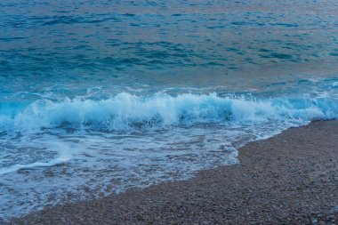 The coast of the Mediterranean Sea in the evening. Clean beach on the Mediterranean Sea. Beach with pebbles and sand