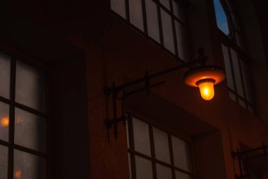Night lantern on a dark street. The yellow incandescent lamp illuminates the darkness.