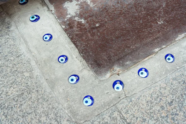 devil\'s eye on the floor near the house. Turkish hallway with blue eyes on the floor. blue eye from damage immured in biton