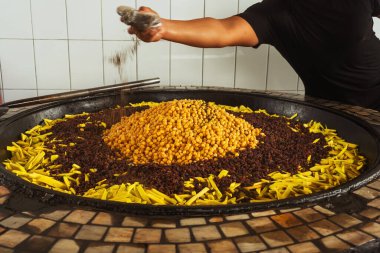 a man adds spices to Uzbek pilaf in a cafe. uzbek cook in pilaf center. preparation of the national Uzbek dish.