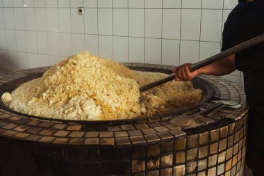 a man cooks uzbek pilaf in a cafe. uzbek cook in pilaf center. preparation of the national Uzbek dish