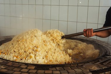 a man cooks uzbek pilaf in a cafe. uzbek cook in pilaf center. preparation of the national Uzbek dish