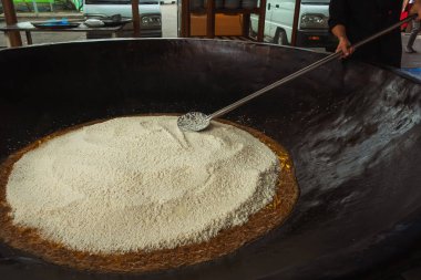 mixing rice in plov center of tashkent. cooking pilaf in uzbekistan. mixing pilaf in a cast iron cauldron for tourists