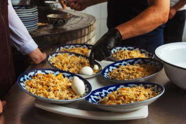 laying pilaf on Uzbek plates. packing pilaf in the pilaf center. lunch time in a cafe in tashkent. fatty rice with butter national dish of uzbekistan