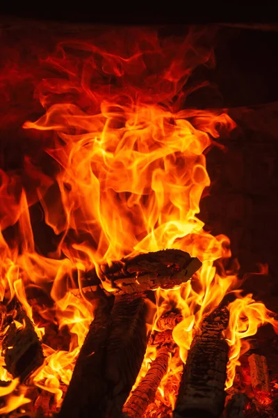 Big fire in the Uzbek oven for cooking pilaf. orange fire on a dark background in a brick oven. fire for cooking