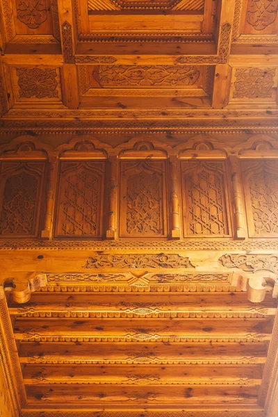 carved wooden elements on the wall of the Uzbek house. texture of carved wood in the tourist temple of tashkent. handmade by uzbek carpenters in tashkent