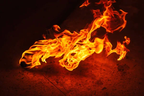 orange fire from an iron torch. Burning kerosene on a cane rag. burning staff on the stone floor. dangerous fire from flammable liquid at fire show