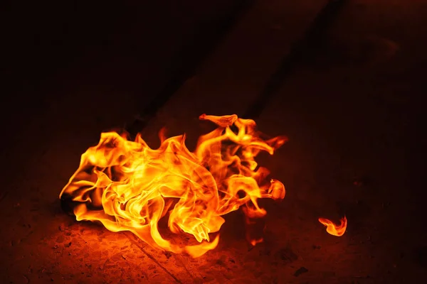 orange fire from an iron torch. Burning kerosene on a cane rag. burning staff on the stone floor. dangerous fire from flammable liquid at fire show