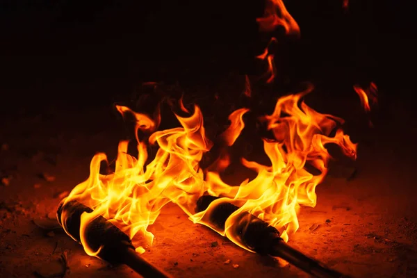 orange fire from an iron torch. Burning kerosene on a cane rag. burning staff on the stone floor. dangerous fire from flammable liquid at fire show